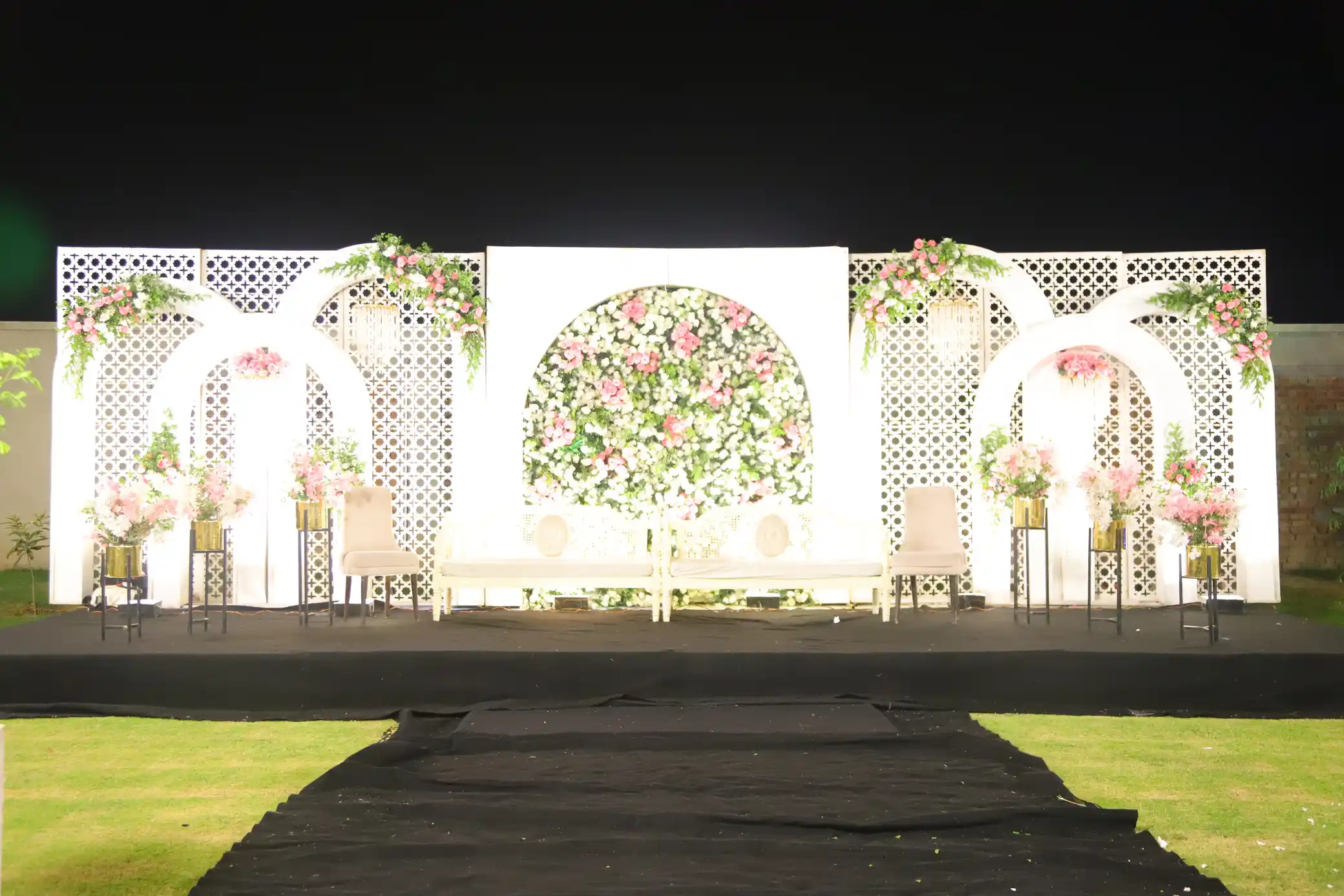 Lawn event arrangement with couches and floral decorations